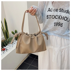Detail of khaki pleated cloud bag with soft leather texture and stylish knot accents