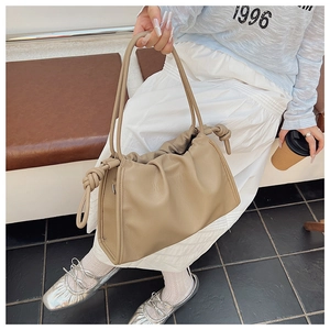 Detail of the soft khaki pleated cloud bag showing the unique handle knot and ruched leather