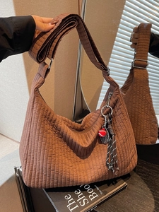 Brown quilted tote bag with pleated texture and adjustable shoulder strap for women