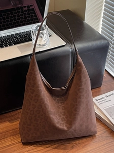 Vintage leopard print tote bag in frosted brown leather shown in a cozy home office setting