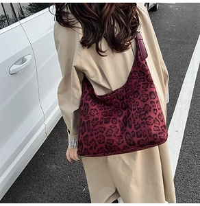 Detail showing vintage leopard print hobo bag in deep burgundy worn with a beige coat