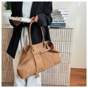 Detail of a large camel tote bag with matte suede texture and elegant pleated design details