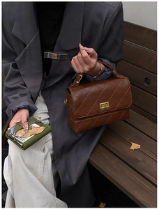 Détail d'un sac à main matelassé vintage avec fermoir doré et texture cuir marron
