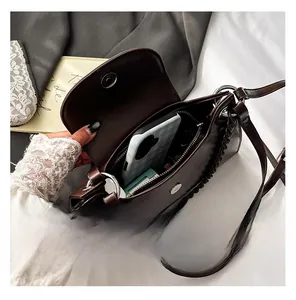 Detail view of dark brown PU leather crossbody bag interior showing storage space