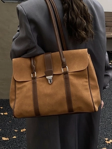 Grande borsa tote in pelle scamosciata marrone con fibbia in metallo indossata a spalla