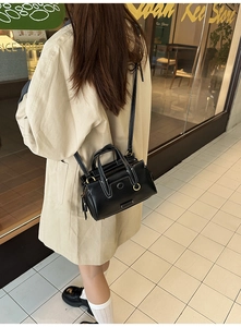 Detail of black leather tote bag with contrast stitching and adjustable strap