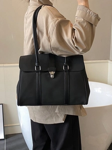 Borsa tote nera opaca retrò con chiusura in metallo argento indossata a spalla su modella