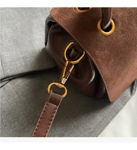 Detail of dark brown leather handbag with premium gold hardware and stitching