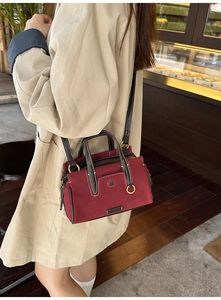 Close-up of burgundy tote bag showing soft suede texture and leather strap detail