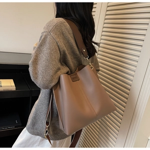 Borsa a secchiello marrone con ampia tracolla in pelle e ganci in metallo dorato da donna