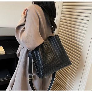 Dettaglio borsa shopper nera intrecciata con tracolla larga a contrasto moderna