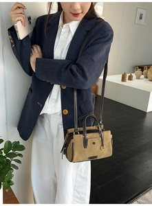 Detail of khaki suede Boston bag with contrast white stitching and brown leather handles