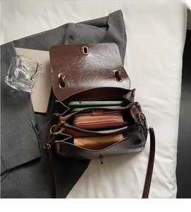Detail of dark brown leather shoulder bag interior showing three spacious compartments