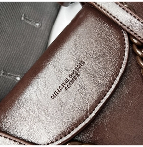 Detailed macro view of dark brown oil wax leather flap with NINAITEI CLASSIC logo engraving
