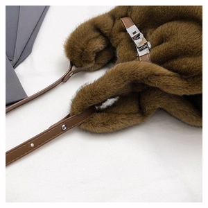Détail de la texture en fausse fourrure marron foncé et du fermoir rotatif argenté du sac