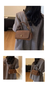 Detail of vintage brown leather handbag with gold twist lock and knotted top handle