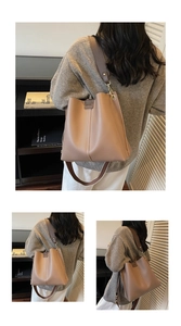 Dettaglio della borsa a secchiello in pelle color cuoio con cuciture e tracolla larga