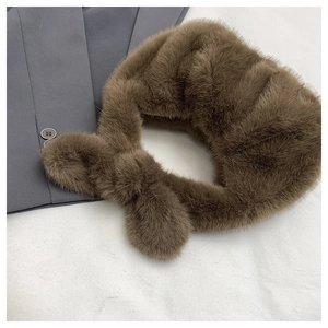 Détail de l'écharpe en fausse fourrure marron foncé avec un design croisé élégant