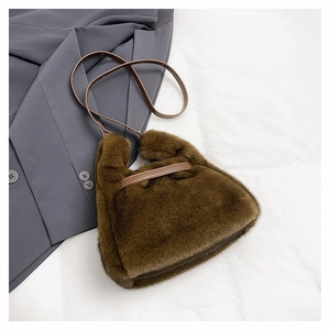 Détail du sac à main en fausse fourrure marron avec bandoulière sur blazer gris