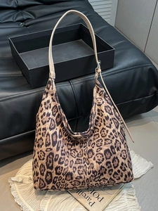 Retro leopard print hobo shoulder bag with adjustable brown strap on decorative background