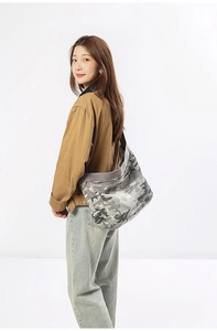 Detail view of camouflage canvas crossbody bag showing large capacity and wide strap