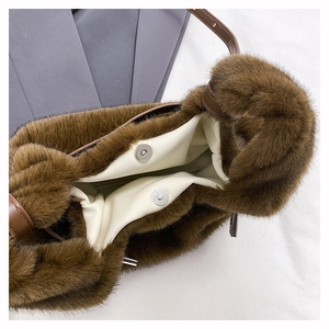 Détail du sac à main en fausse fourrure marron avec fermoir aimanté et bandoulière
