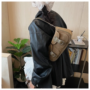 Detailansicht der braunen Wildleder-Baguette-Tasche mit Vintage-Schnallen an einem Model