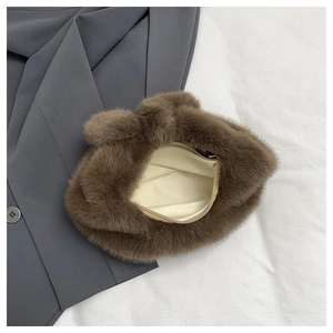 Détail de la fermeture à glissière du sac en peluche marron et de la doublure beige