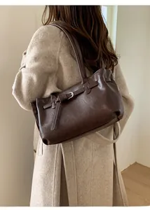 Close-up of a dark brown oil-wax leather tote bag on a white wool coat