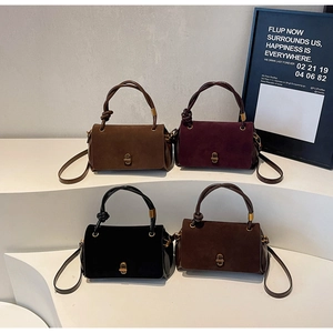 Detailed view of four suede handbags in tan, wine, black and coffee on display