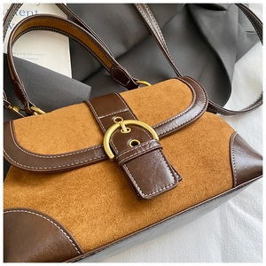 Dettaglio borsa hobo vintage in pelle marrone e camoscio con cuciture a contrasto e fibbia