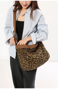 Close-up of leopard print canvas crossbody bag with adjustable wide brown strap