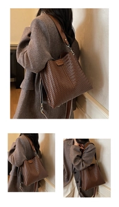 Dettaglio di una grande borsa tote intrecciata marrone con tracolla larga e fibbia