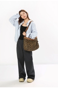 Leopard print canvas crossbody bag shown on model with wide brown shoulder strap