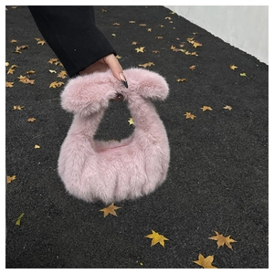 Gros plan du sac à main en fausse fourrure rose montrant sa texture pelucheuse