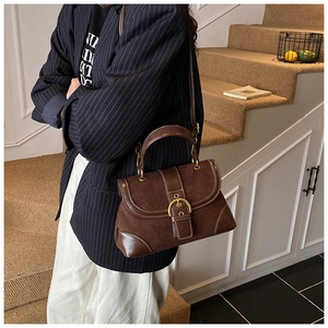 Dettaglio della borsa a sella vintage marrone con patchwork in pelle scamosciata