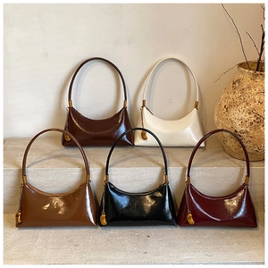Détail de sacs demi-lune brillants déclinés en noir, crème, marron, camel et bordeaux chic