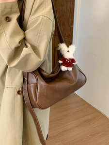 Vintage brown leather hobo shoulder bag for women with bear charm and white stitching detail
