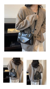 Detail of black wax leather handbag featuring gold twist lock and dual top handles
