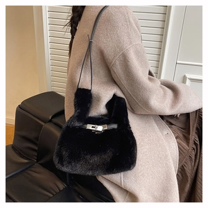 Gros plan détaillé d'un sac bandoulière en fausse fourrure noire avec fermoir rotatif argenté