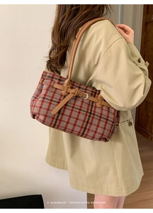 Detail of retro plaid tote bag featuring red and blue tweed with brown leather straps