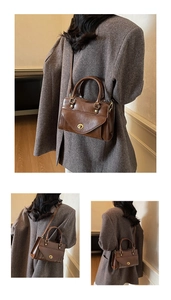 Detailed view of dark brown vintage faux leather handbag with gold metal twist lock and handles