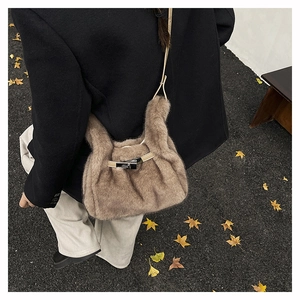 Détail du sac à bandoulière en peluche camel avec sangle en cuir et boucle argentée