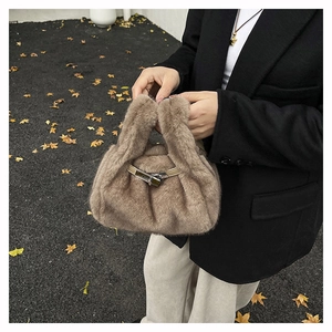 Vue détaillée d'un sac à main en peluche marron clair avec fermoir rotatif en métal chic