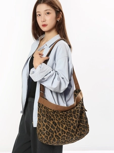 Large leopard print canvas hobo crossbody bag styled on a model for daily commute