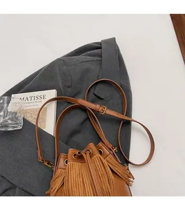 Gros plan sur un sac seau marron en suédine avec de longues franges et un cordon