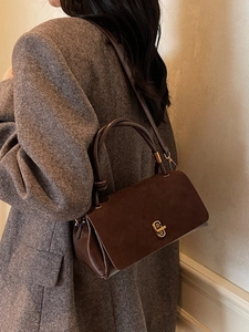 Brown vintage leather handbag with gold metal lock and shoulder strap for women