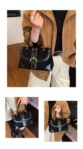 Dettaglio della borsa a sella vintage nera con cuciture a contrasto bianche e fibbia d'oro