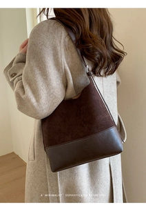 Detail showing brown retro tote bag with dual-texture suede and leather stitching