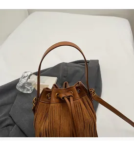 Vue détaillée du sac seau marron avec franges et texture en nubuck synthétique